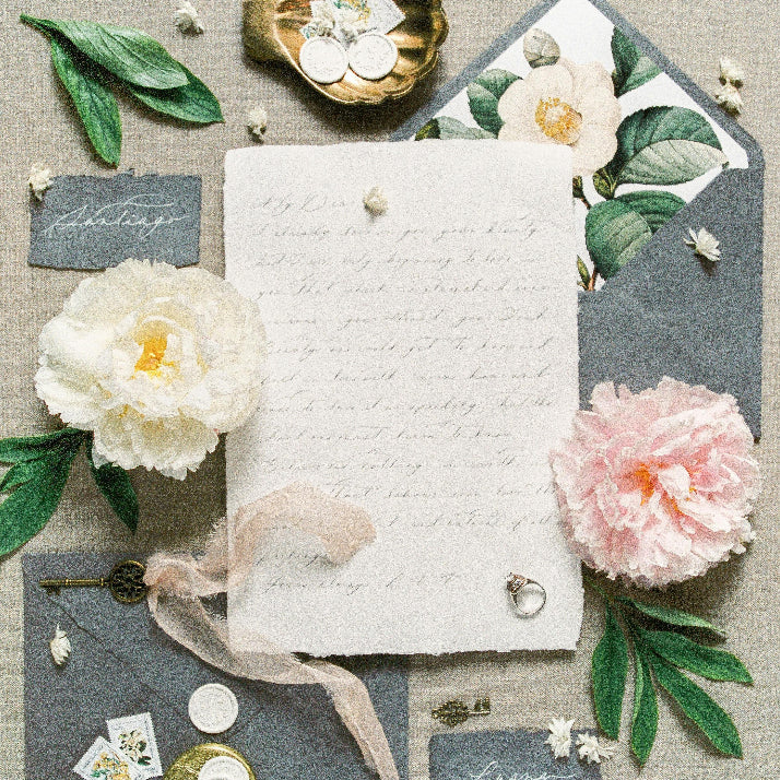 Stationery set with flowers and ribbons on a textured surface